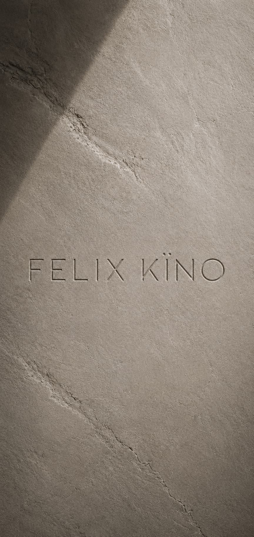 The words FELIX KÏNO engraved into a sunlit stone surface